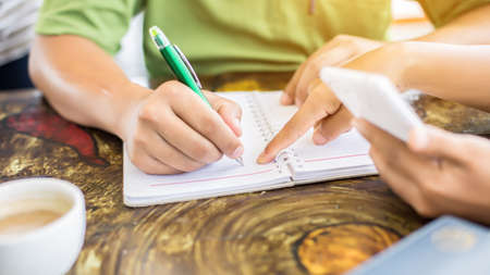 Image of document with charts on background of male and female working , business conceptの写真素材