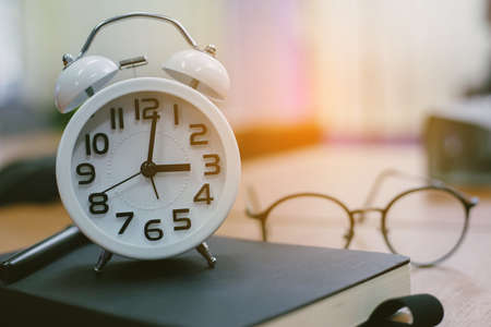 retro clock time at 9 o'clock with notebook or memo on wood table, times of memory writing diary...