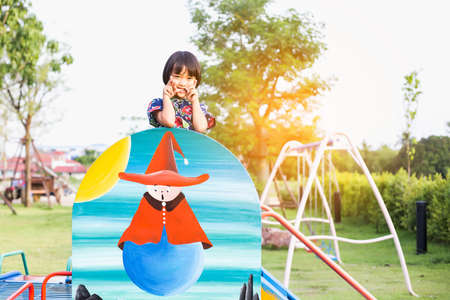 beautiful smiling cute girl on a playgroundの写真素材