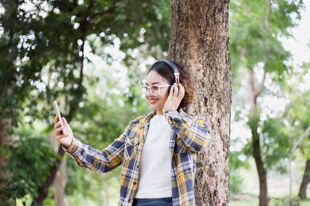 A young girl lying on the grass listening to music, relax on soft and blurred background