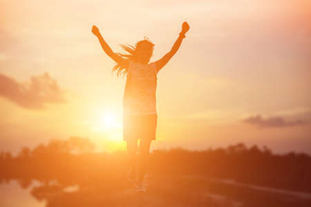 strong confidence woman open arms under the sunset.の写真素材