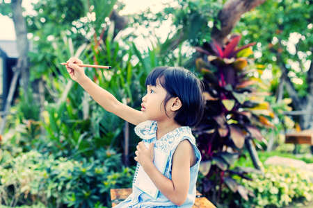 Happy cute child girl on the blur green background.の写真素材