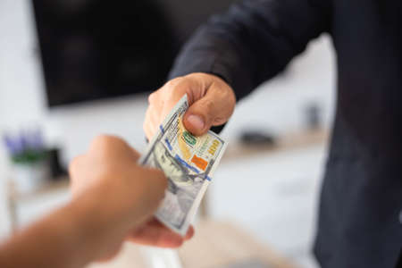 Entrepreneurs are about to sign a contract that allows partners to file cash for bribes.の写真素材