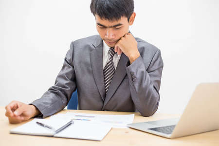 Cheerful businessman taking notes while working in the office.の写真素材