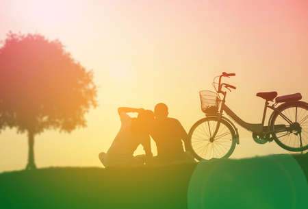 silhouette of couple driving bike happy time sunsetの写真素材