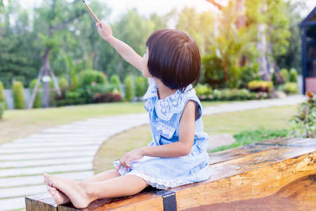 Happy cute child girl on the blur green background.の写真素材