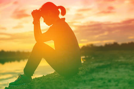 silhouette of a young woman standing aloneの写真素材