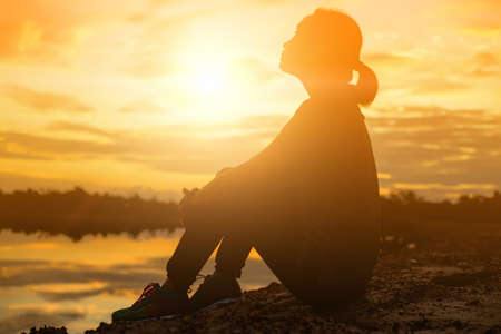 silhouette of a young woman standing aloneの写真素材