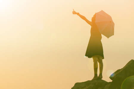 Silhouette of woman praying over beautiful sky backgroundの写真素材