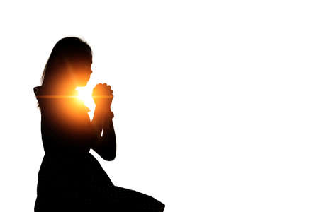 Silhouette of woman praying over beautiful sky backgroundの写真素材