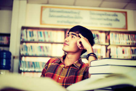 The young man is studying for knowledge in the library