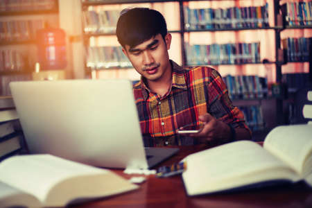 The young man is studying for knowledge in the libraryの写真素材