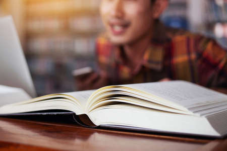 The young man is studying for knowledge in the libraryの写真素材