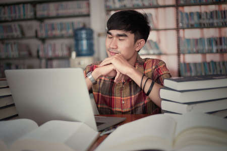 The young man is studying for knowledge in the libraryの写真素材
