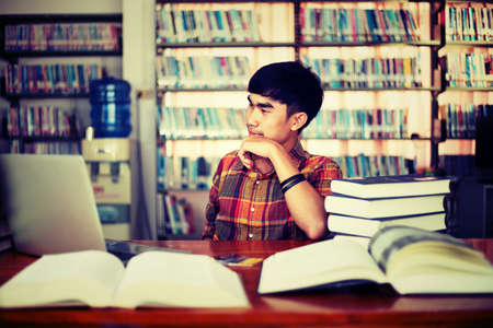 The young man is studying for knowledge in the libraryの写真素材
