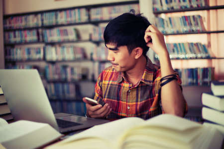 The young man is studying for knowledge in the libraryの写真素材