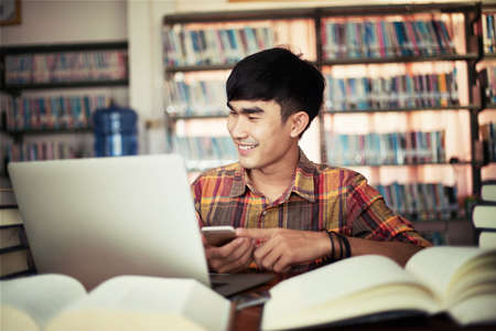 The young man is studying for knowledge in the libraryの写真素材