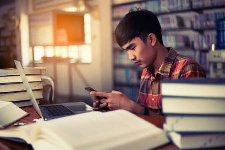 The young man is studying for knowledge in the libraryの写真素材