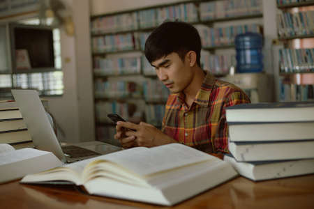 The young man is studying for knowledge in the libraryの写真素材