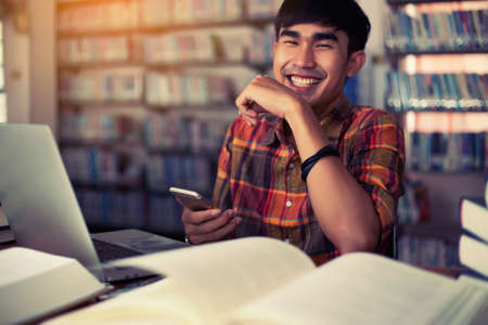The young man is studying for knowledge in the libraryの写真素材