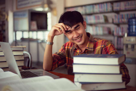 The young man is studying for knowledge in the libraryの写真素材