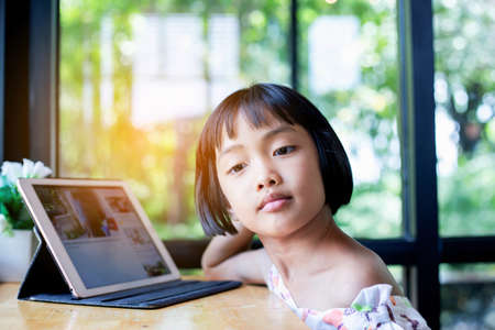 Happy kids using a laptop computer at homeの写真素材