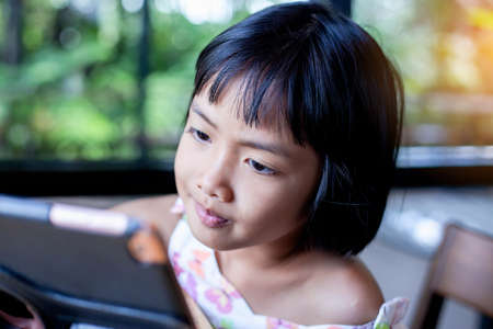 Happy kids using a laptop computer at homeの写真素材