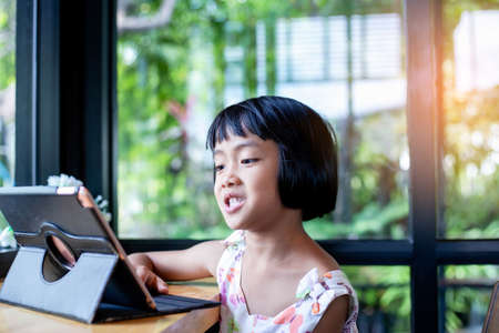 Happy kids using a laptop computer at homeの写真素材