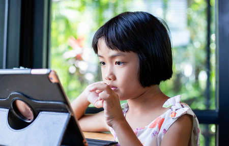 Happy kids using a laptop computer at homeの写真素材