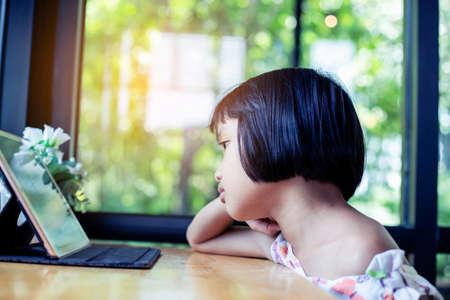 Happy kids using a laptop computer at homeの写真素材