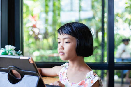 Happy kids using a laptop computer at homeの写真素材