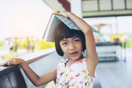The happy schoolgirl sitting at the desk with booksの写真素材