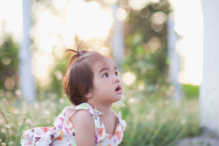 Cute girl smiling brightly in the setting sunの写真素材