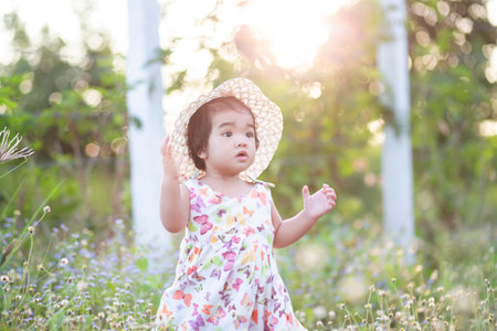 Cute girl smiling brightly in the setting sunの写真素材