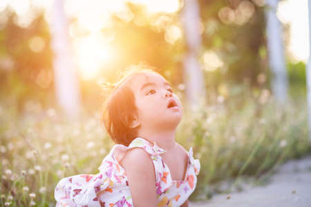 Cute girl smiling brightly in the setting sunの写真素材
