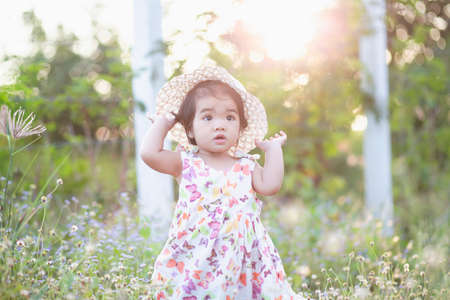 Cute girl smiling brightly in the setting sunの写真素材