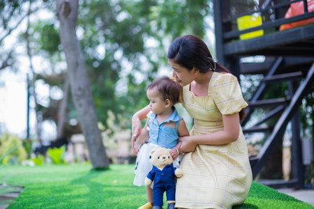 Happy mother and daughter walking in the gardenの写真素材
