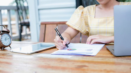 Image of document with charts on background of male and female working , business conceptの写真素材