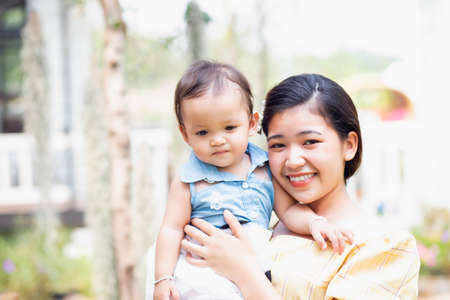 Happy mother and daughter walking in the gardenの写真素材