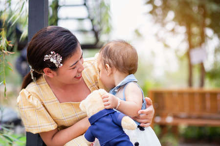 Happy mother and daughter walking in the garden