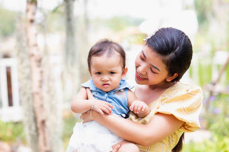 Happy mother and daughter walking in the gardenの写真素材