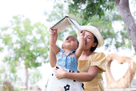 Mother and daughter relax and read a bookの写真素材