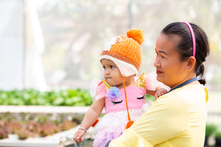 Mother holding daughter's hand for a walk in the gardenの写真素材