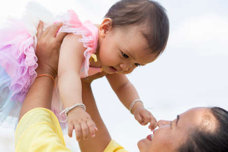 Mother holding daughter's hand for a walk in the gardenの写真素材