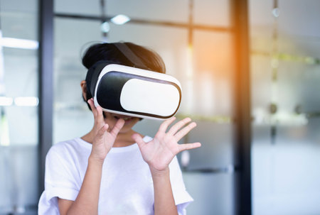 Young girl kid child play virtual reality game hold vr glasses and surprised. Cyber space and virtual gamingの写真素材