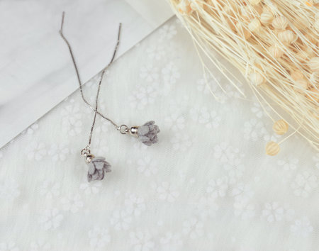 Grey pendant earrings, its shape is a flower.