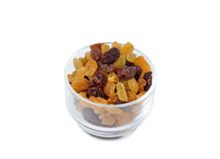 Dried raisins in glass on white background
