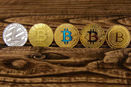  golden bitcoin stand in a row on wooden tableの写真素材