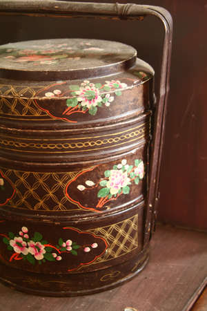 close up of traditional three storey tiffin carrier painted with flower motifsの写真素材
