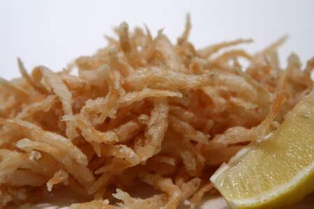plate of deepfried silverfish garnished with a lemonの写真素材